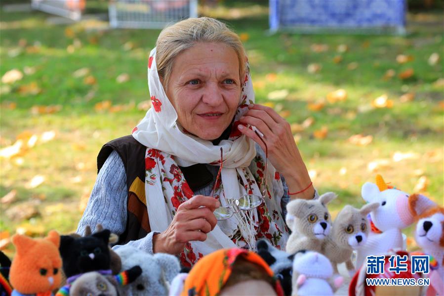 9月26日，在白俄罗斯首都明斯克郊区，一名女子展售自己制作的玩具。 随着当地秋收的基本结束，白俄罗斯各地相继举办农业展销节等活动，欢庆秋收。 新华社发（任科夫摄）
