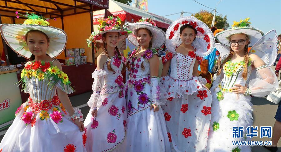 9月26日，在白俄罗斯首都明斯克郊区，几名女孩身着色彩鲜艳的服饰参加农业展销节。 随着当地秋收的基本结束，白俄罗斯各地相继举办农业展销节等活动，欢庆秋收。 新华社发（任科夫摄）
