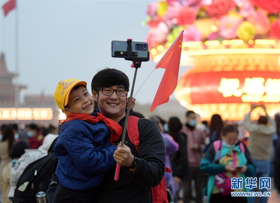 10月1日，人们在北京天安门广场拍照游览。 当日是国庆节，全国各地的人们用各种方式欢度节日。 新华社记者 李贺 摄