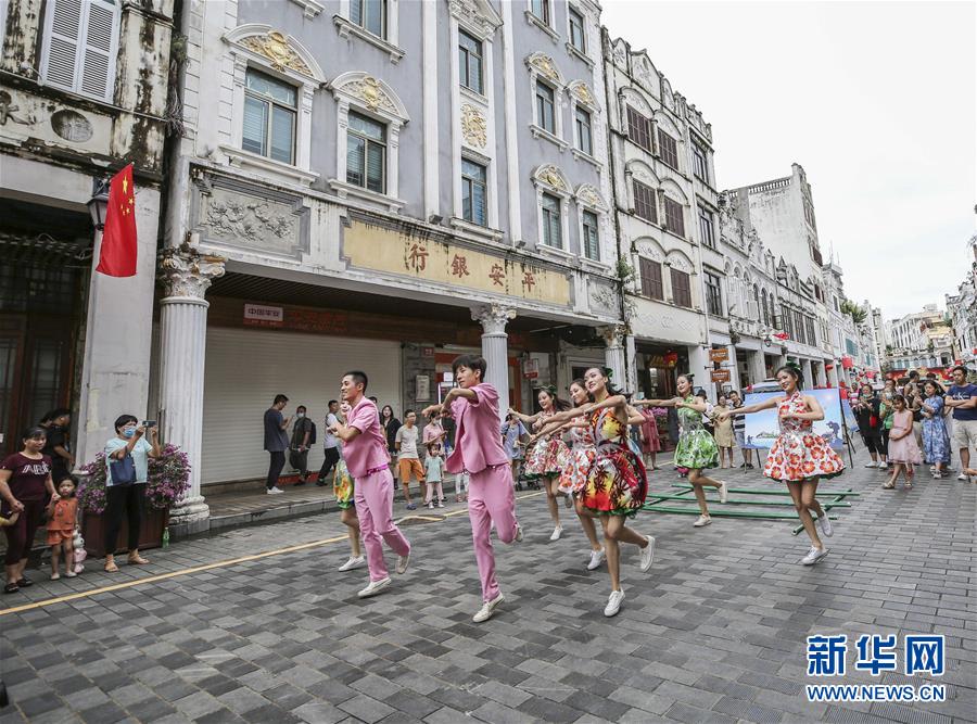 10月2日，演员在海口骑楼老街表演“快闪”。 当日是国庆假期第二天，许多游客来到海口骑楼老街参观游览。 新华社记者 张丽芸 摄