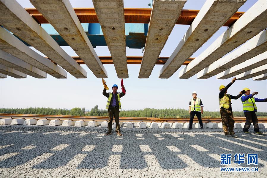 10月5日，在中铁二局等单位承建的水曹铁路施工现场，铁路建设者在河北唐山滦州茨榆坨镇进行铺轨作业。水曹铁路位于唐山市境内，本线北端接轨卑水线可达首钢水厂矿区，南端直达曹妃甸港区矿石码头和通用码头。 国庆、中秋“双节”期间，全国各地依然有建设者在工地一线施工，确保各建设工程稳步推进。 新华社记者 牟宇 摄