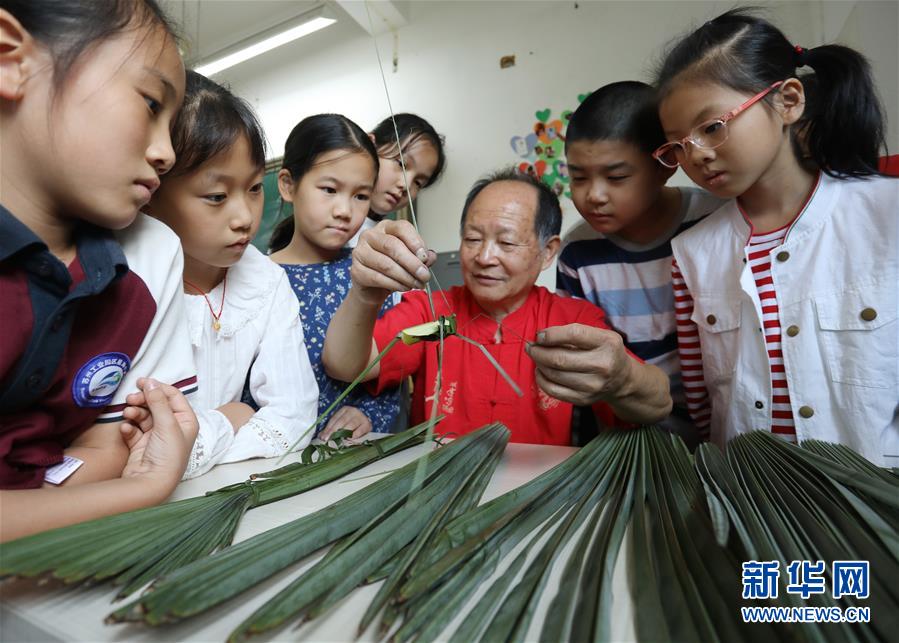 10月9日，民间艺人在苏州工业园区星海小学向孩子们讲解棕编技艺。 当日，江苏苏州工业园区星海小学开展“传统文化手工制作体验“活动，孩子们在当地手工艺人的指导下，学习剪纸、棕编等手工技艺，感受传统文化。 新华社发（杭兴微 摄）