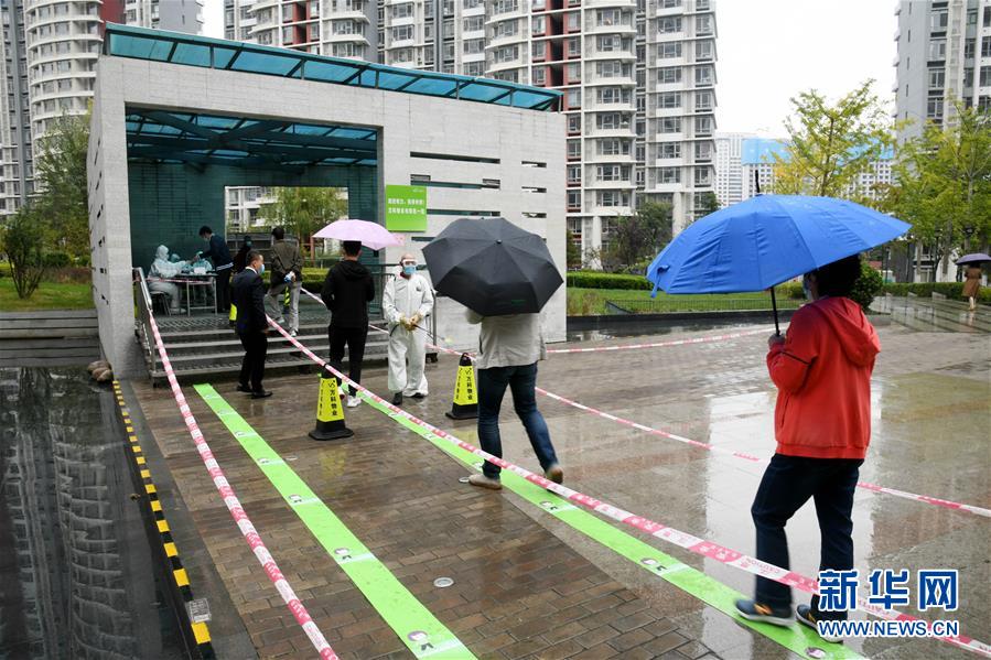 10月14日，市民在青岛市市北区河西街道一检测点排队等候进行核酸检测采样。 当日，青岛市卫生健康委员会在新闻发布会上通报，截至10月14日18时，青岛全员核酸检测已采样882万余份，已出结果541万余份，未发现新的阳性样本。 新华社记者 李紫恒 摄