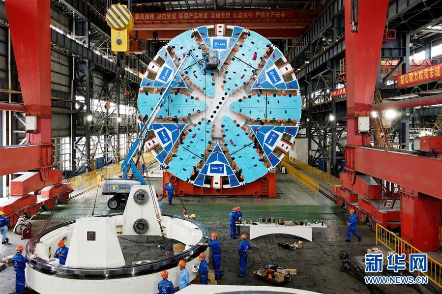 10月15日，在隧道股份上海隧道工程有限公司机械制造分公司生产车间，工人在对“骐跃”盾构机进行安装调试（无人机照片）。 近日，由隧道股份上海隧道工程有限公司自主研发制造的超大直径盾构机“骐跃”在上海浦东成功调试下线。“骐跃”整机总重约为3200吨，总长约为99米，其中主机长度约为16米，刀盘切削直径达14.05米。 新华社记者 方喆 摄