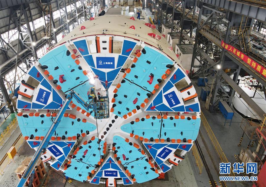 10月15日，一名工人在生产车间对“骐跃”盾构机进行焊接作业（无人机照片）。 近日，由隧道股份上海隧道工程有限公司自主研发制造的超大直径盾构机“骐跃”在上海浦东成功调试下线。“骐跃”整机总重约为3200吨，总长约为99米，其中主机长度约为16米，刀盘切削直径达14.05米。 新华社记者 方喆 摄