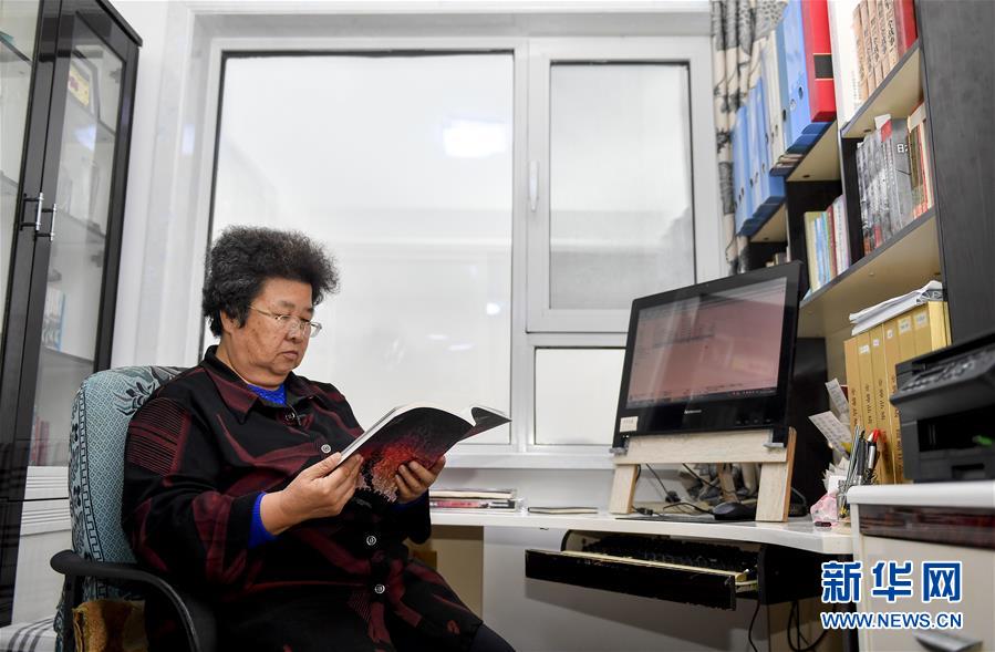 孙艳华在家中翻阅书籍核对信息（10月11日摄）。 新华社记者 许畅 摄