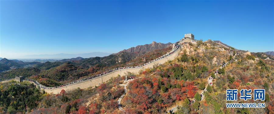 10月24日，游人在八达岭长城游览（无人机全景照片）。 深秋时节，北京八达岭长城红叶进入最佳观赏期，红叶映长城美如画卷。 新华社记者 陈晔华 摄