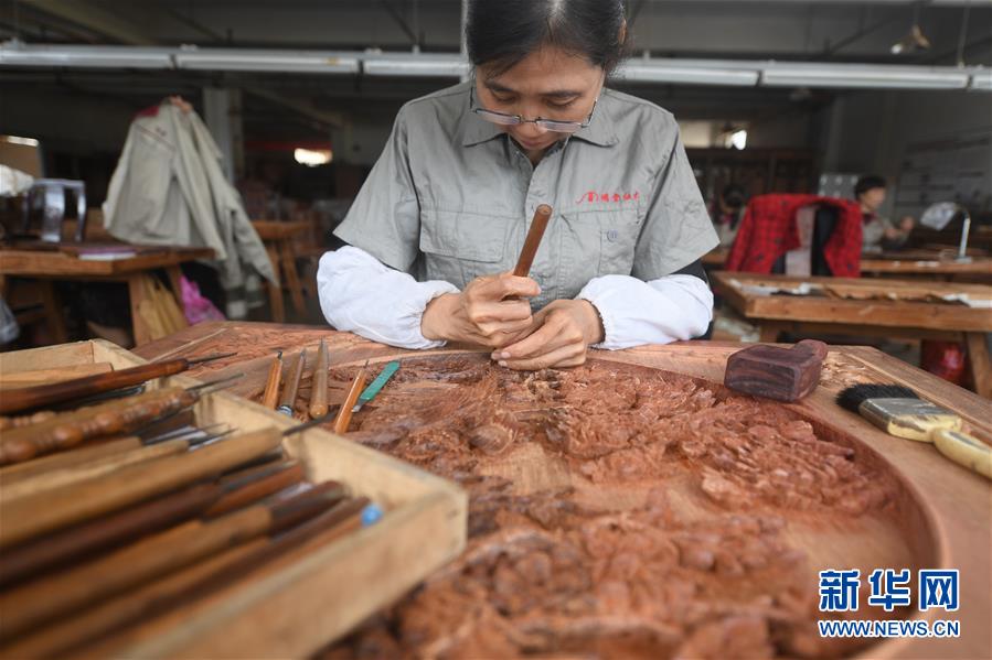 工作人员在浙江省工艺美术大师张向荣创立的明堂红木家具雕花车间内雕刻作品（10月20日摄）。  新华社记者 翁忻旸 摄