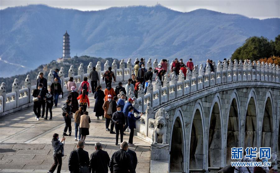 10月27日，游人在颐和园十七孔桥观赏秋色。 秋意渐浓，大批市民和游客来到北京颐和园观赏秋景。 新华社记者 李欣 摄
