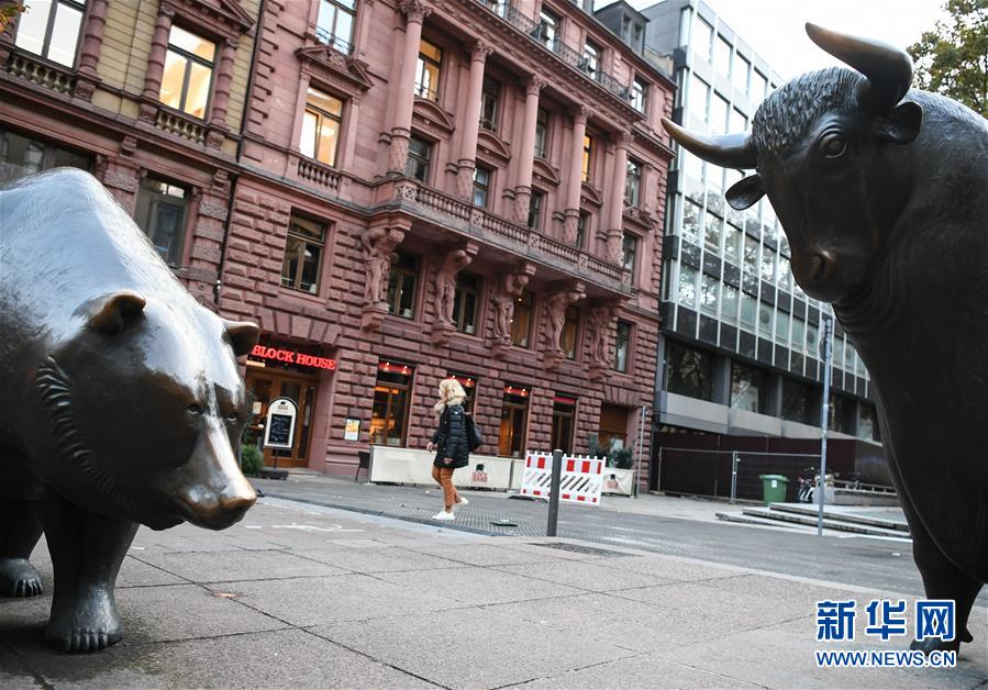 这是10月28日在德国法兰克福证券交易所外拍摄的“熊牛对峙”雕塑。 德国法兰克福股市DAX指数28日下跌503.06点，跌幅为4.17%，报收于11560.51点。 新华社记者逯阳摄