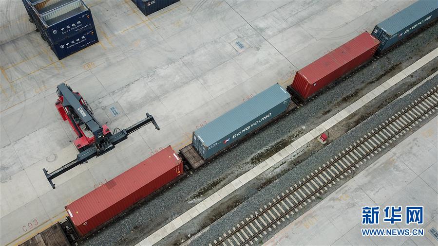 9月15日，在长春国际陆港，工作人员操作正面起重机向货运列车上搬运货柜（无人机照片）。新华社记者 张楠 摄