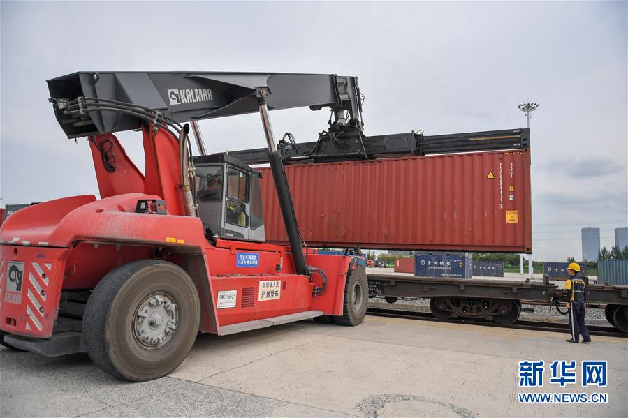 9月15日，在长春国际陆港，工作人员操作正面起重机向货运列车上搬运货柜。新华社记者 张楠 摄