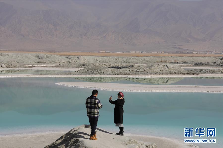 10月30日，游客在翡翠湖边拍照留念。 翡翠湖位于青海省海西蒙古族藏族自治州，由于湖底深浅不一、所含矿物质浓度不同，湖水呈现不同深度的绿色，宛若镶嵌在戈壁上的“绿宝石”。 新华社记者 央秀达珍 摄