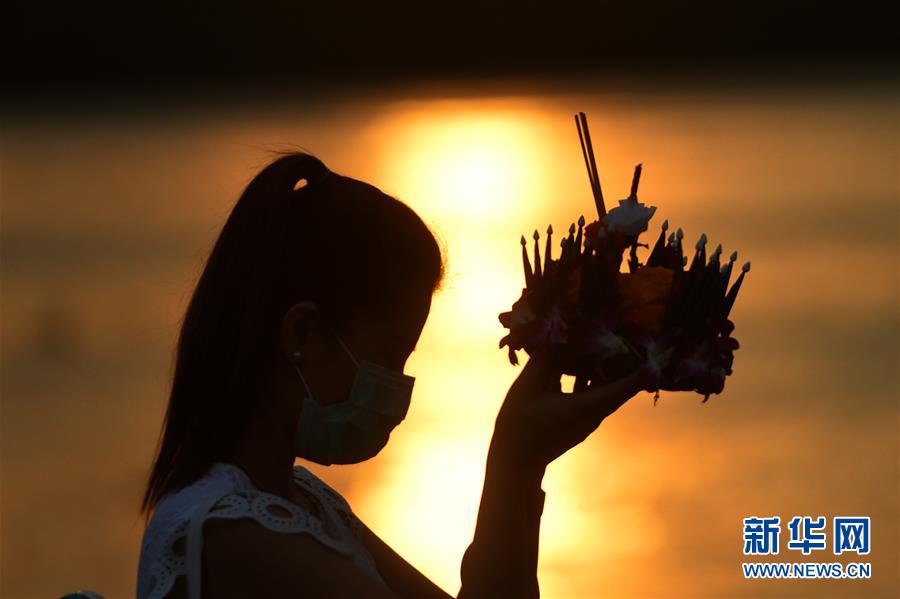 10月31日，一名女子在泰国曼谷湄南河边放水灯。 当日是泰国传统节日水灯节，泰国各地民众前往河流或湖泊沿岸施放水灯，祈求流水带走厄运，未来幸福如意。 新华社发（拉亨摄）