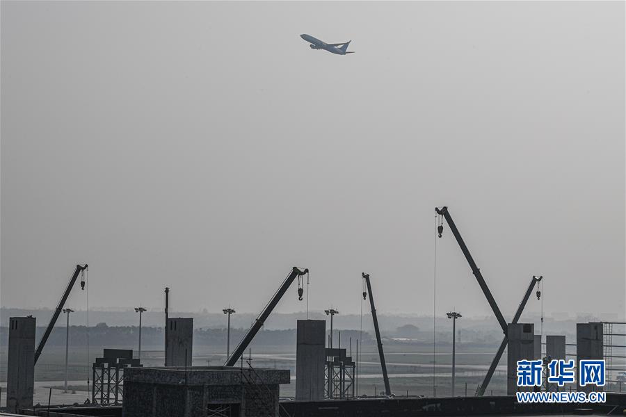 11月2日，一架飞机从海口美兰空港一站式飞机维修基地项目工地上空飞过。 目前，正在建设中的海口美兰空港一站式飞机维修基地项目正在进行主体施工和装修，项目建成后，将形成一站式飞机维修平台，服务国内外航空公司。 新华社记者 蒲晓旭 摄