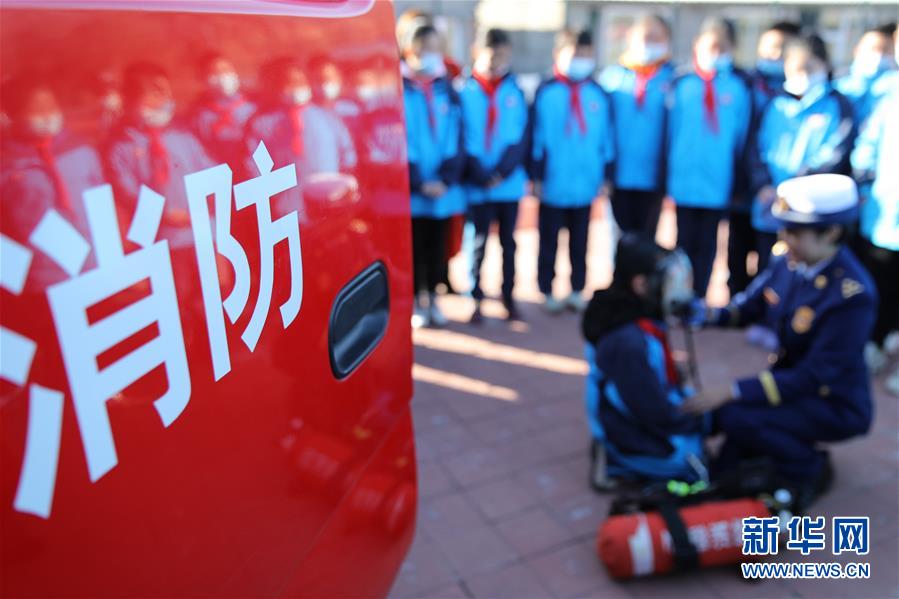 11月3日，在承德市双桥区普宁小学，学生在消防救援人员指导下体验使用消防器材。 当日，河北省承德市双桥区消防救援大队与普宁小学联合开展消防进校园安全互动体验教育活动。学生们通过体验救生设备、安全使用消防器材等，在互动活动中学习消防知识，提升自救能力，迎接“119消防宣传日”。 新华社发（刘环宇 摄）