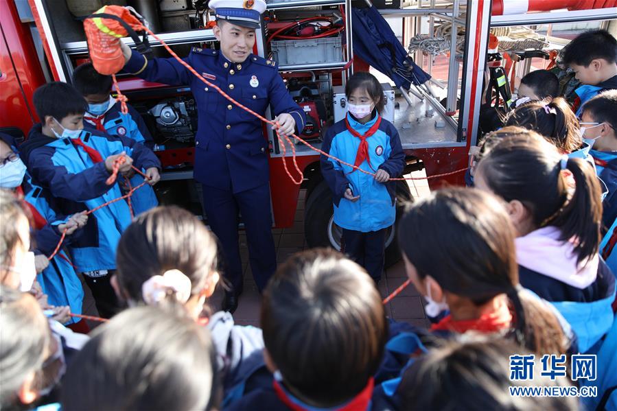 11月3日，在承德市双桥区普宁小学，学生在消防救援人员指导下体验使用救援绳。 当日，河北省承德市双桥区消防救援大队与普宁小学联合开展消防进校园安全互动体验教育活动。学生们通过体验救生设备、安全使用消防器材等，在互动活动中学习消防知识，提升自救能力，迎接“119消防宣传日”。 新华社发（刘环宇 摄）