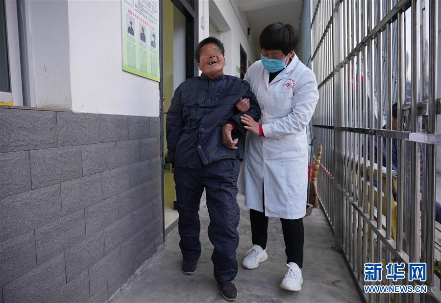 11月3日，在陕西省延安市黄陵县残疾人托养康复中心，医护人员扶着一名残疾人出门散步。 新华社记者 才扬 摄