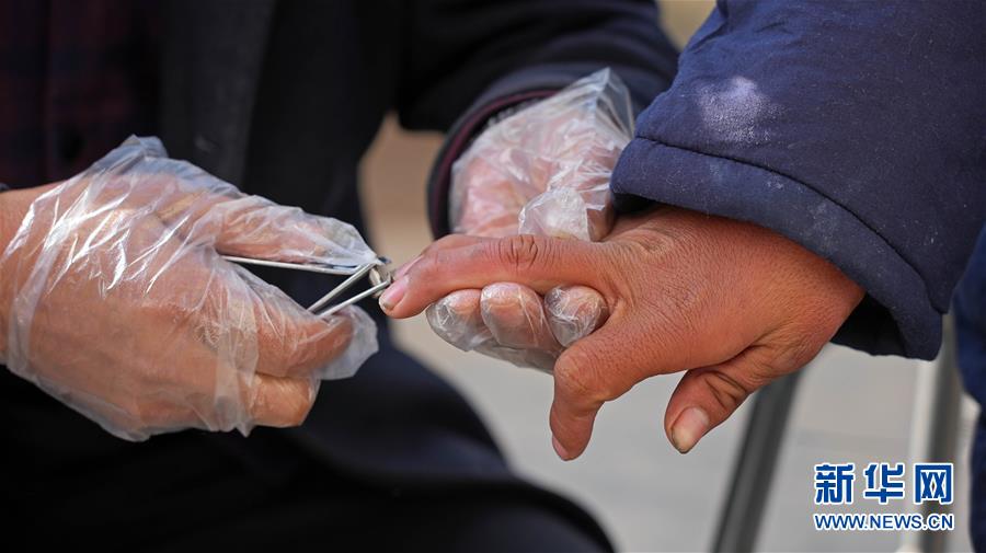 11月3日，在陕西省延安市黄陵县残疾人托养康复中心，医护人员为残疾人剪指甲。 新华社记者 才扬 摄