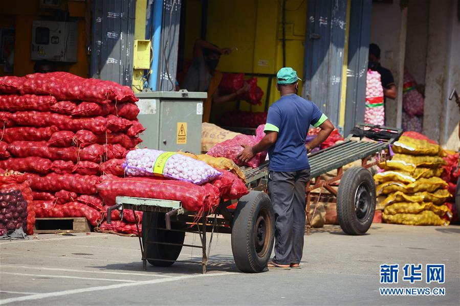 11月3日，在斯里兰卡首都科伦坡一处市场，一名商贩装载准备分发给市民的生活必需品。为控制疫情蔓延，斯里兰卡警方宣布自30日起在包括科伦坡在内的整个西部省实行宵禁，持续至9日。 新华社发（阿吉特·佩雷拉摄）