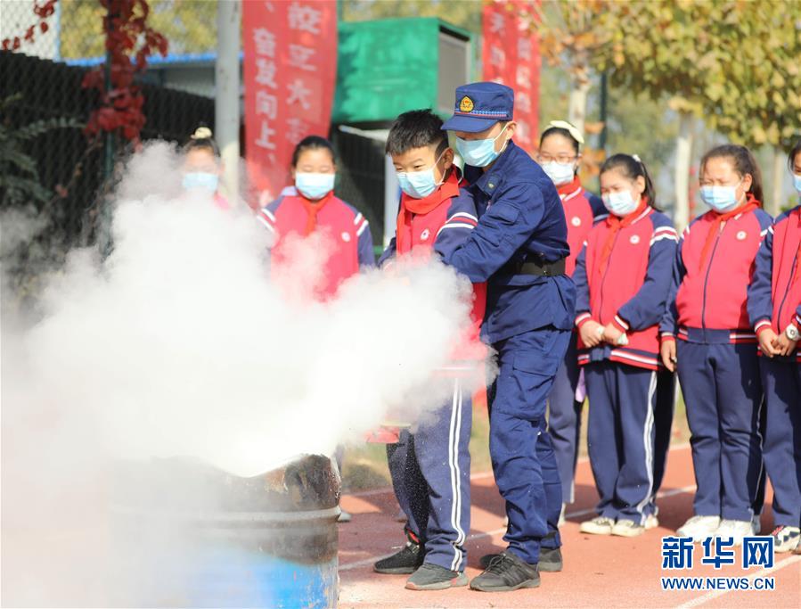 11月4日，固安县第七小学学生在消防救援人员的指导下学习使用灭火器灭火。 当日，河北省固安县消防救援大队开展“119消防安全教育进校园”主题宣传活动。通过消防演练、消防装备展示、消防互动体验、宣讲消防安全知识、讲解灭火器材使用方法等，进一步提高学生的消防安全意识和逃生自救能力。 新华社发（门丛硕 摄）