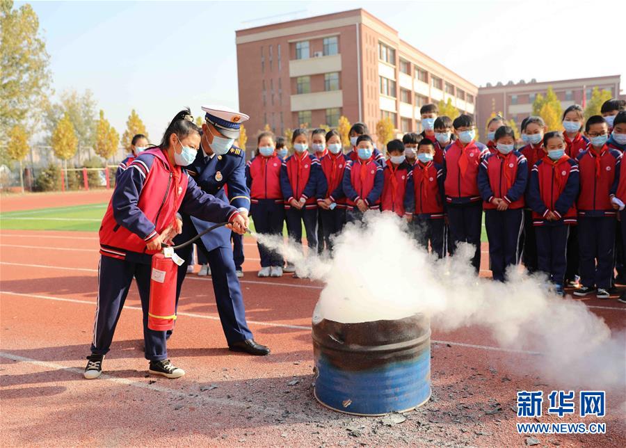 11月4日，固安县第七小学学生在消防救援人员的指导下学习使用灭火器灭火。 当日，河北省固安县消防救援大队开展“119消防安全教育进校园”主题宣传活动。通过消防演练、消防装备展示、消防互动体验、宣讲消防安全知识、讲解灭火器材使用方法等，进一步提高学生的消防安全意识和逃生自救能力。 新华社发（门丛硕 摄）