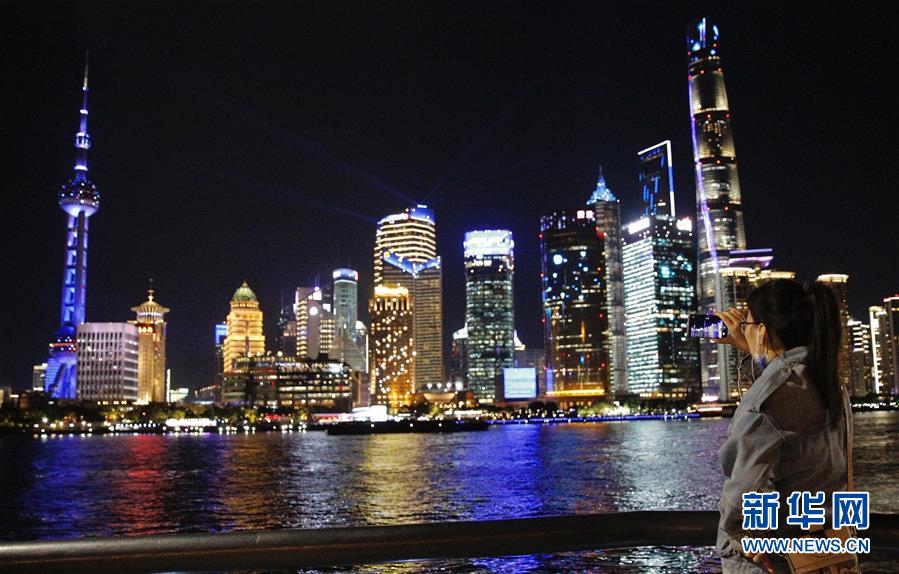 11月4日，游客在外滩拍摄观赏光影秀。 当晚，上海陆家嘴开始上演进博会主题光影秀，多彩灯光随着音乐律动闪耀，展示上海开放、创新、包容的城市品格。 新华社记者 张玉薇 摄