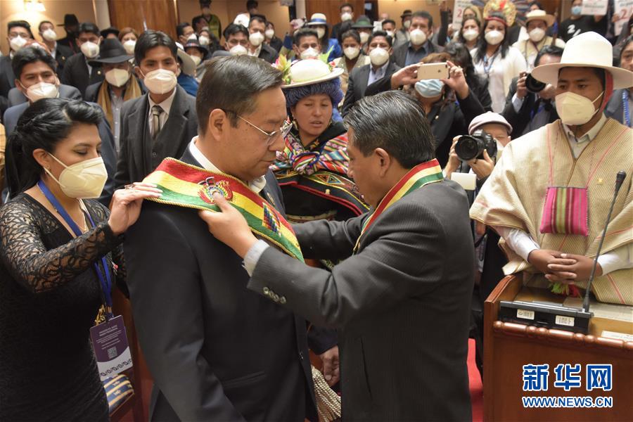 11月8日，在玻利维亚行政首都拉巴斯，玻利维亚当选副总统戴维·乔克万卡（前右）为当选总统路易斯·阿尔塞（前中）戴上绶带。 玻利维亚当选总统路易斯·阿尔塞8日在该国行政首都拉巴斯宣誓就职，任期5年。 新华社/玻利维亚通讯社