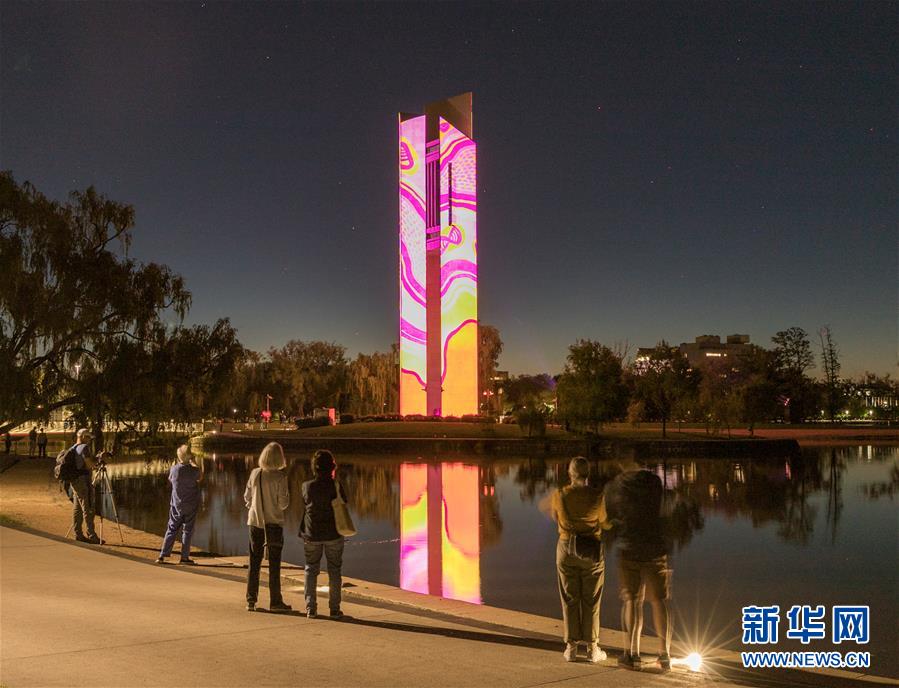 11月10日，在澳大利亚首都堪培拉举行的原住民文化艺术展上，人们观看国家钟楼上的投影。 澳大利亚首都堪培拉11月8日至15日在国家钟楼举行原住民文化艺术展。 新华社发（刘畅畅 摄）