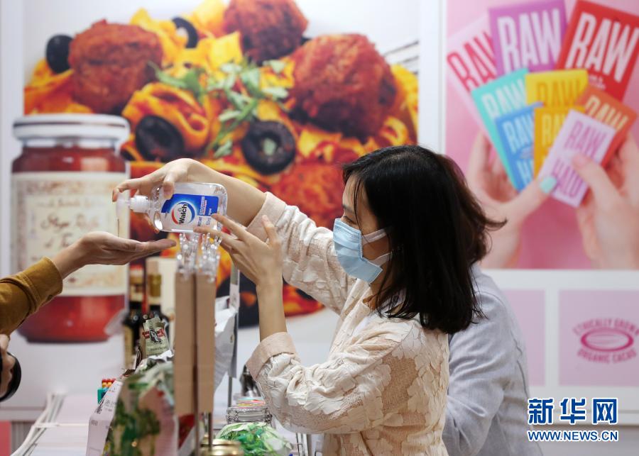 11月11日，展览现场一名工作人员为参观者提供洗手液。当日，“香港餐饮展暨亚洲高端食品展”在香港会议展览中心举行，约200家企业参展。新华社记者 李钢 摄