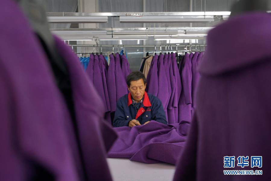 11月11日，清河县一家羊绒制品生产企业的员工缝制羊绒大衣。新华社记者 牟宇 摄