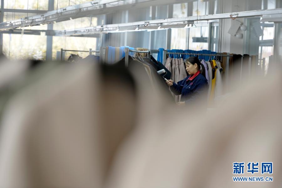 11月11日，清河县一家羊绒制品生产企业的员工整理羊绒大衣。新华社记者 牟宇 摄