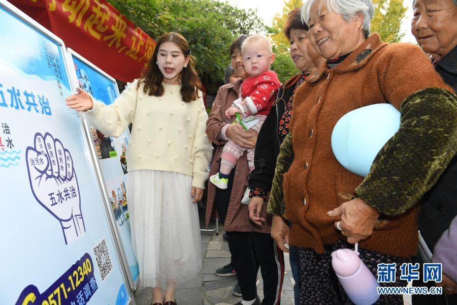 11月16日，宣讲员（左一）向藤桥港河道沿岸玉堂桥社区的居民进行“五水共治”宣传。2013年起，浙江湖州吴兴区环渚街道开始对辖区内污染较严重的藤桥港河道进行整治，强化落实河长制，加大水生植物种植率，并通过手机APP及时上报巡河问题，使河道水环境面貌和水质获得明显改善。新华社记者 翁忻旸 摄