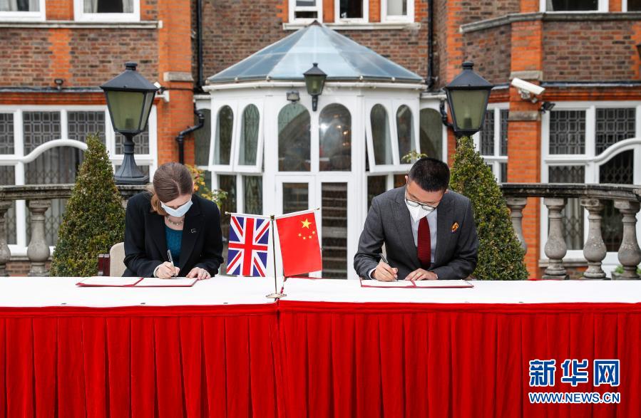 10月16日，在英国伦敦，代表中国国家文物局的中国驻英国大使馆文化处一秘于果（右）和代表英国大都会警察局的探员苏菲·海斯签署文物接收确认书。今年1月以来，国家文物局与外交、海关等部门紧密合作，在我驻英国使馆大力支持下，克服疫情的不利影响，近期成功将流失英国25年的68件走私文物追索回国。新华社记者 韩岩 摄