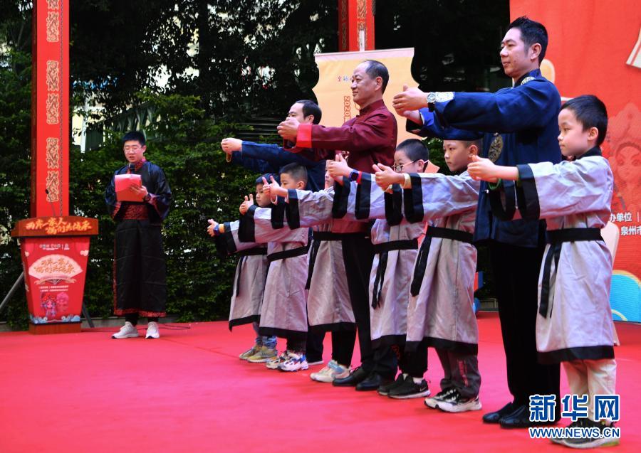 两岸学子穿着传统服饰向木偶戏传承人行拜师礼后，一起向现场观众致意（11月21日摄）。新华社记者 魏培全 摄