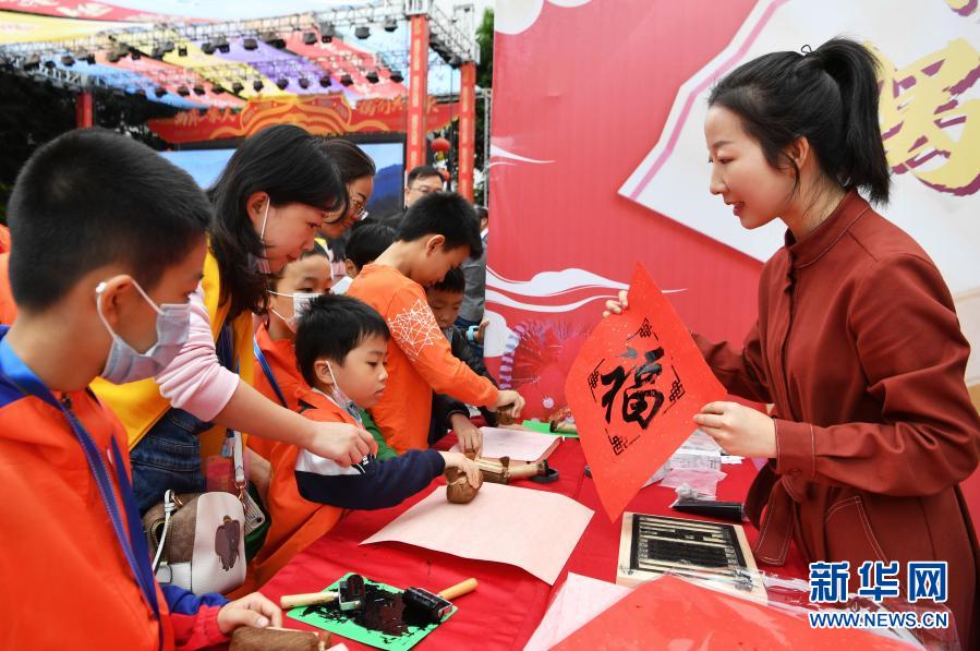 两岸青少年在木刻拓印摊位上学习传统拓印技艺（11月21日摄）。新华社记者 魏培全 摄