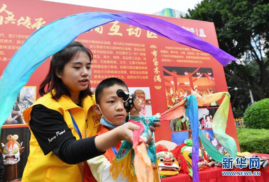 木偶研学营的一名小朋友在互动区学习布袋木偶表演技艺（11月21日摄）。新华社记者 魏培全 摄