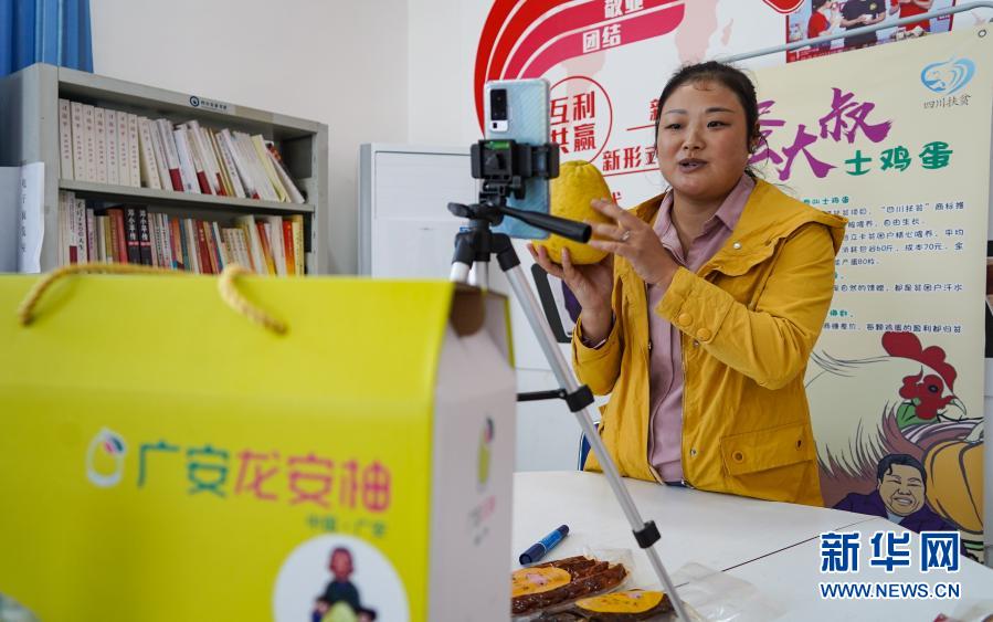 外地务工返乡的青年村民杨红梅在广安市龙安乡革新村直播带货（11月13日摄）。新华社记者 王曦 摄