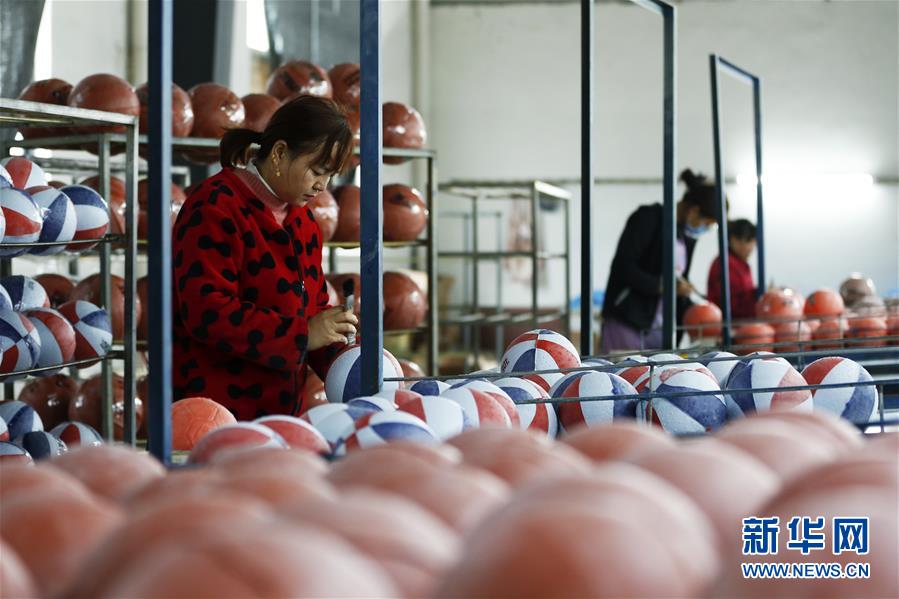 11月25日，在泗洪经济开发区一制球企业，曾经在外打工的返乡农民李彩英（左）在生产车间忙碌。 江苏省宿迁市泗洪县是劳务输出大县。近年来，泗洪县采取一系列措施鼓励企业提供长期用工、短期用工、季节用工、临时用工等不同就业岗位，吸引在外务工的劳动力返乡灵活就业，确保收入不减少的前提下又能照顾家庭，助推当地乡村振兴。 新华社发（许昌亮 摄）