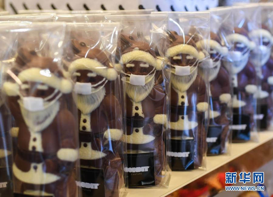 这是11月25日在德国法兰克福一家糕点店内拍摄的戴口罩的圣诞老人造型巧克力。新华社记者逯阳摄