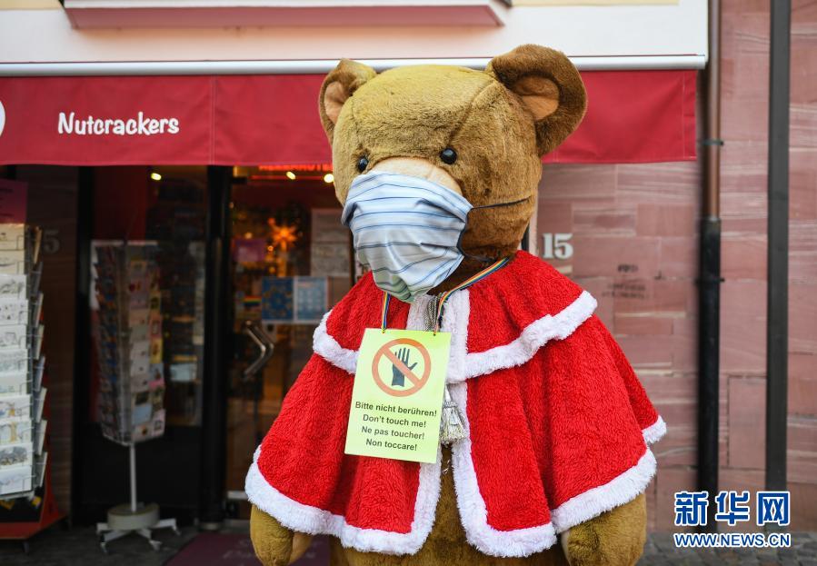 这是11月25日在德国法兰克福一家纪念品商店前拍摄的戴口罩的玩具熊。新华社记者逯阳摄