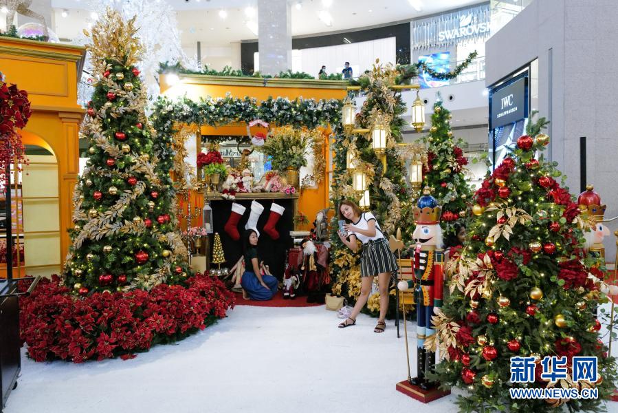 11月26日，在马来西亚吉隆坡，人们在一家商场的圣诞节装饰旁拍照。随着圣诞节临近，吉隆坡节日气氛渐浓。新华社记者 朱炜 摄