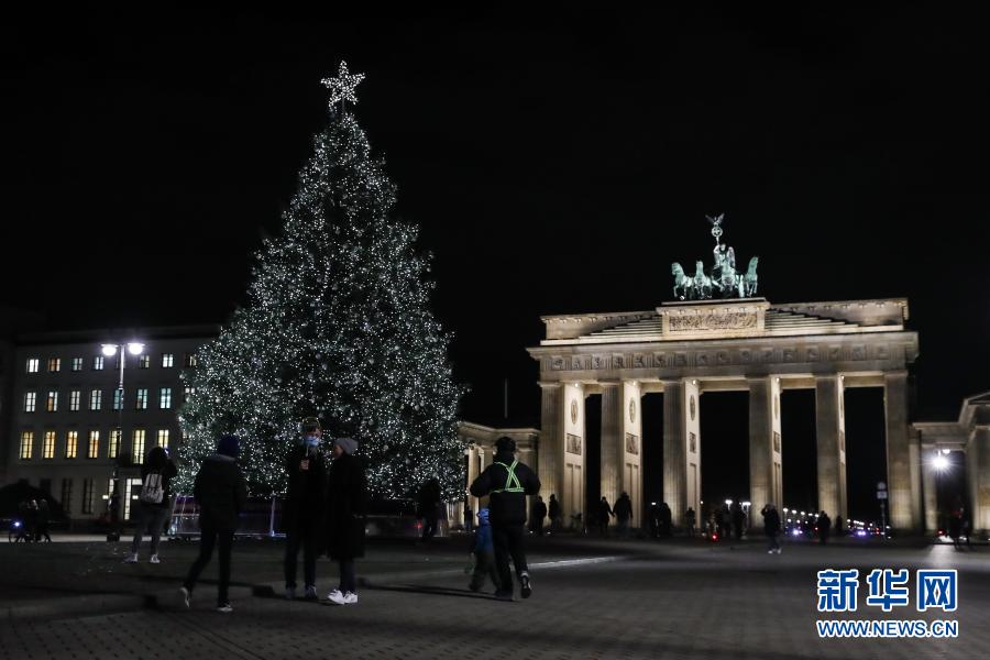 这是11月29日在德国首都柏林勃兰登堡门拍摄的被点亮的圣诞树。当日，德国柏林勃兰登堡门前的圣诞树被灯饰点亮。今年柏林多处圣诞市场及相关庆祝活动由于新冠疫情被取消。新华社记者 单宇琦 摄