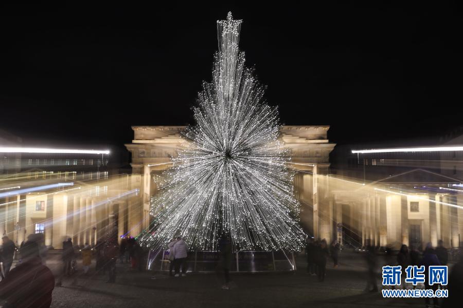 这是11月29日在德国首都柏林勃兰登堡门拍摄的被点亮的圣诞树。当日，德国柏林勃兰登堡门前的圣诞树被灯饰点亮。今年柏林多处圣诞市场及相关庆祝活动由于新冠疫情被取消。新华社记者 单宇琦 摄