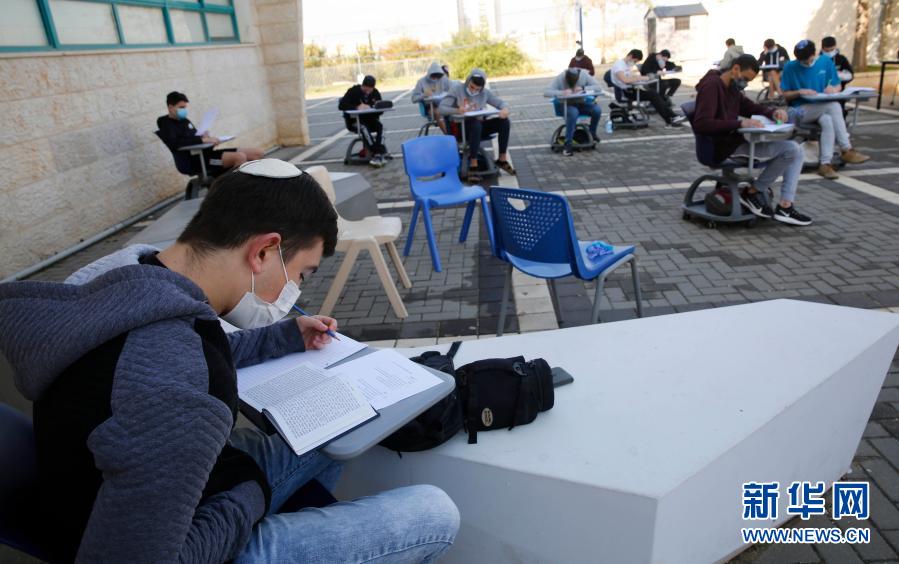 11月29日，佩戴口罩的高中生在以色列莫迪因一所重新开放的高中校园学习。根据以色列政府的批准，发病率较低的“绿色”或“黄色”城市的高中校园自29日起重新开放。新华社发（吉尔·科恩·马根摄）