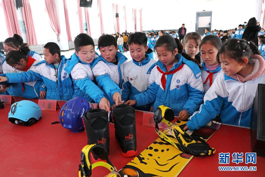 12月1日，河北省尚义县大青沟镇中心小学学生在近距离接触冰雪项目器材。当日，由河北省张家口市科学技术协会主办的“冬奥科普知识进校园”活动走进尚义县大青沟镇中心小学、尚义县第三中学，给学生们讲授冰雪体育运动项目和冬季奥运会的相关知识，让学生们加深对冰雪运动和奥运会的了解，激发青少年参与冰雪运动的热情。新华社发（武殿森 摄）