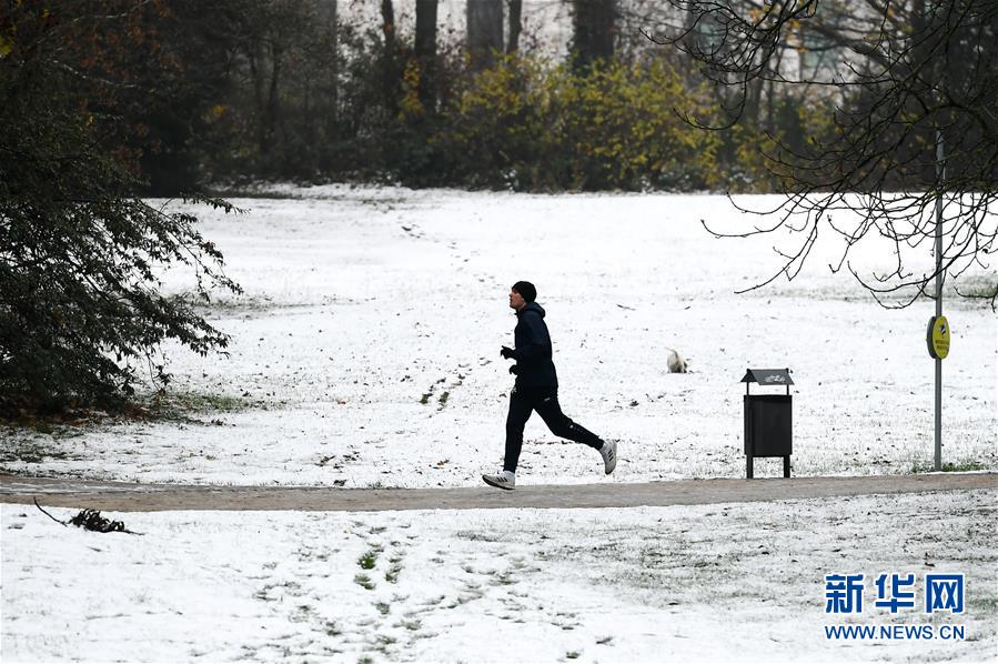 12月1日，一名男子在德国法兰克福一处公园被雪覆盖的小道上跑步健身。 当日，德国法兰克福市降下今冬初雪。 新华社记者 逯阳 摄