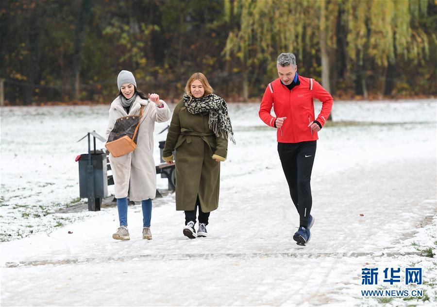 12月1日，人们在德国法兰克福一处公园被雪覆盖的小道上休闲健身。 当日，德国法兰克福市降下今冬初雪。 新华社记者 逯阳 摄