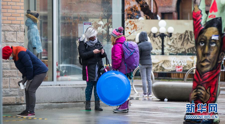 12月4日，在加拿大多伦多，戴口罩的人们排队等候进入一家商店。截至当日下午，加拿大累计新冠确诊病例升至400031例，累计死亡12470例。新华社发（邹峥摄）