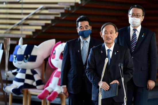 11月16日，日本首相菅义伟（中）在与国际奥委会主席巴赫举行会谈后接受采访。新华社/路透